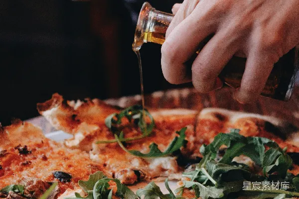高清摄影 一个人将橄榄油倒在披萨上