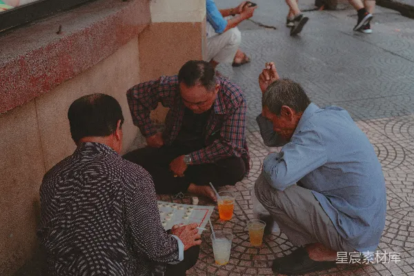 一群男人坐在地上彼此挨着。