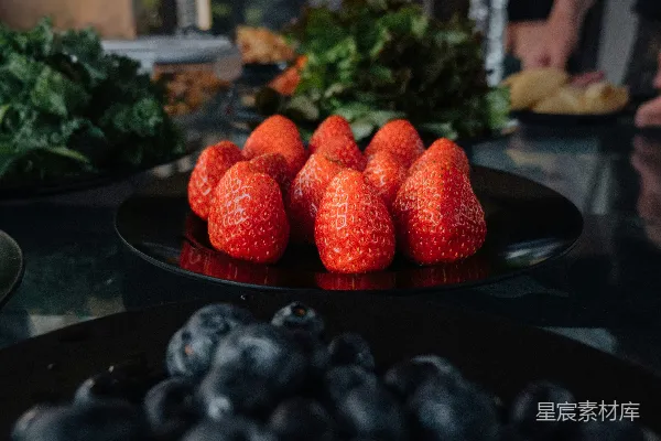 高清摄影 桌面上有一盘草莓和蓝莓。