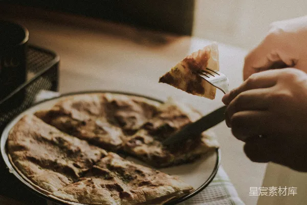 高清摄影 一个人在 plates 上切着比萨饼的一片