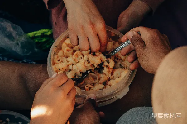 高清摄影 一群人围坐在一个碗的食物旁