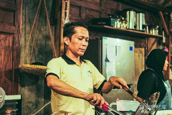 高清摄影 一个男人站在桌子前，桌子上摆满了食物。