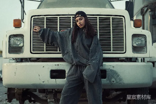 一个女人站在一辆大卡车面前。