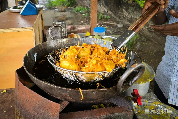 高清摄影 在街边小摊上用大铁锅煎炸 pakoras。