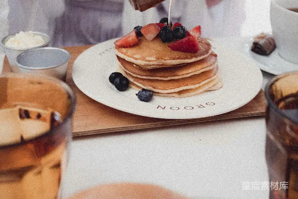 高清摄影 一位女士正在往一叠 Pancakes 上浇糖浆