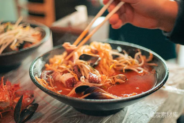高清摄影 手持筷子上方一碗食物的人