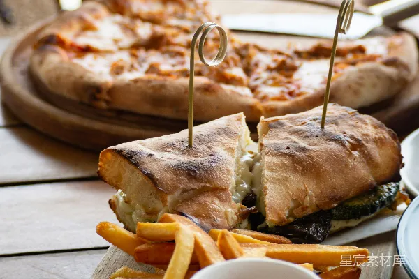 高清摄影 三明治旁边放着炸薯条，旁边是披萨。