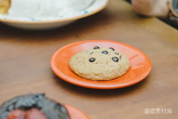 高清摄影 桌上摆放着装有甜甜圈的 plates，上面覆盖着奶油糖霜。
