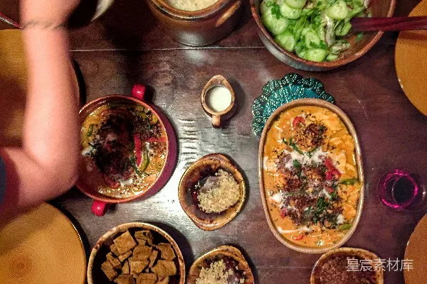 高清摄影 坐在椅子前的一个人面对桌子，桌子上有食物。