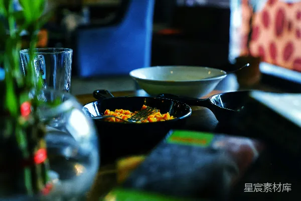 高清摄影 桌子上一个碗的食物旁边放着一束花。