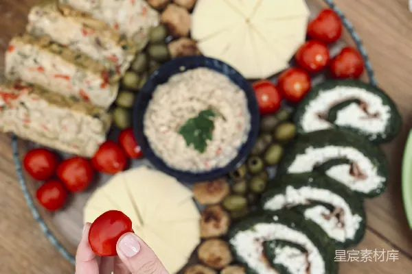高清摄影 手中拿着一块食物的人面前摆放着一盘食物