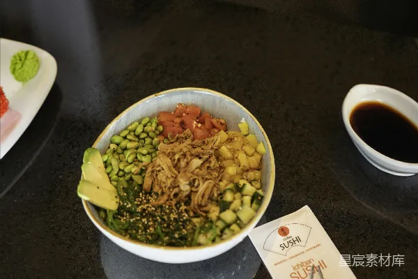 高清摄影 黑暗柜台上的新鲜寿司卷和 poke bowl。