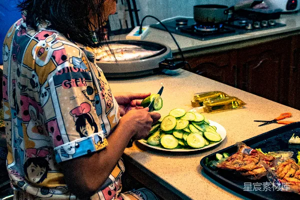 高清摄影 一个女人坐在厨房台面上正在切食物。