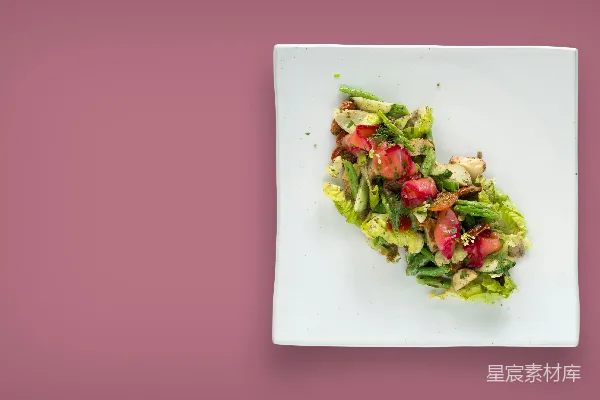 高清摄影 白色 plates 上放着沙拉，放在粉红色的桌子上。