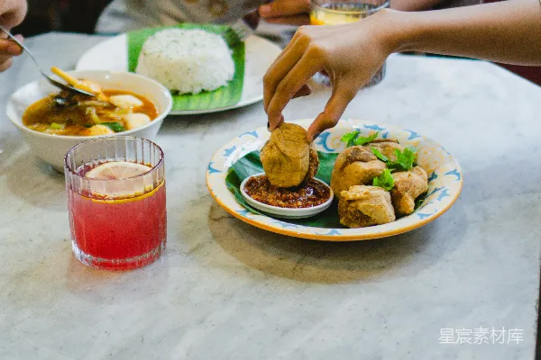 高清摄影 一个男人坐在桌子旁，桌子上有盘食物。