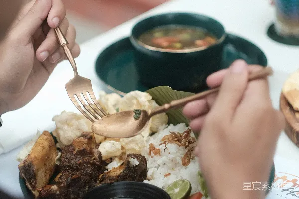高清摄影 一个坐在桌子旁的人手里拿着一份餐食。