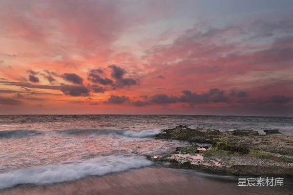 海边的日落时海水拍击着海岸浪花