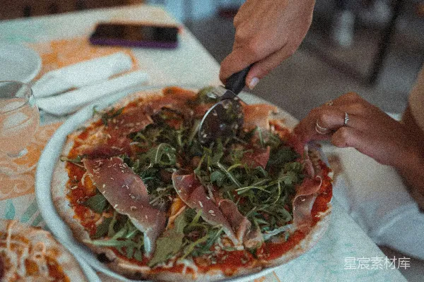 高清摄影 桌上的人正在切披萨。