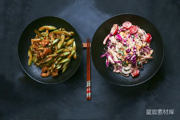 高清摄影 几块黑色的 plates 上放满了食物，放在一张桌子上。