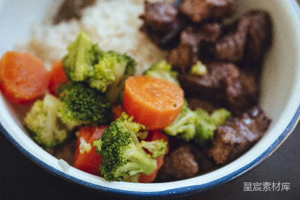 高清摄影 蓝瓷碗中煮好的胡萝卜和 broccoli 米饭