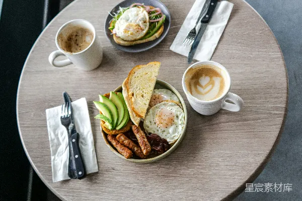 高清摄影 早餐桌上摆着咖啡，背景中有一人。