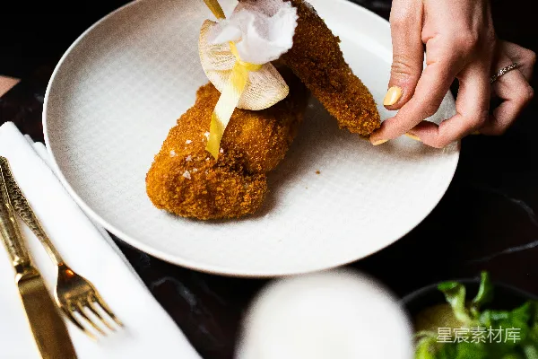 高清摄影 一个人把一块食物放在 plates 上。