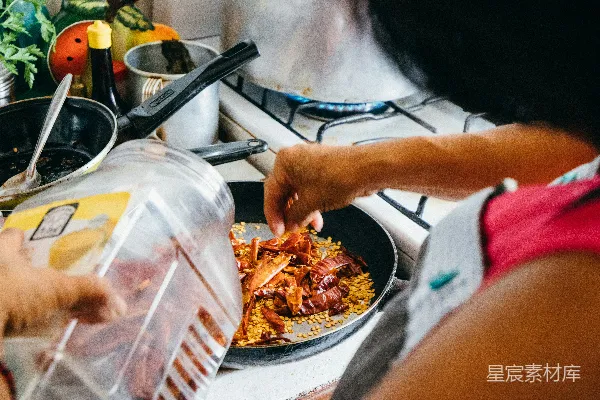 高清摄影 一个女人在炉子上用锅烹饪食物。