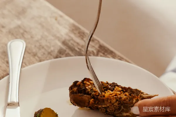 高清摄影 一个人用叉子和刀吃 stuffed bell pepper。