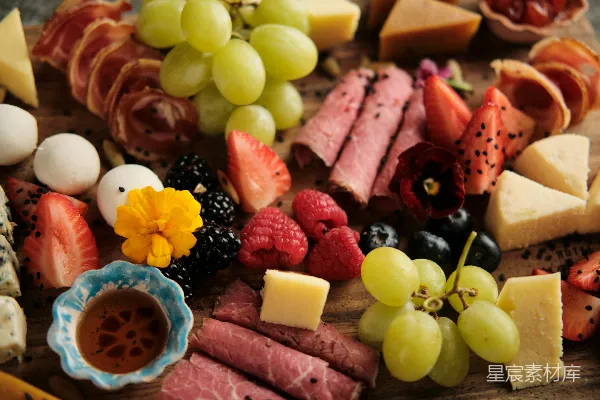 高清摄影 各种奶酪、肉类和水果放在切板上