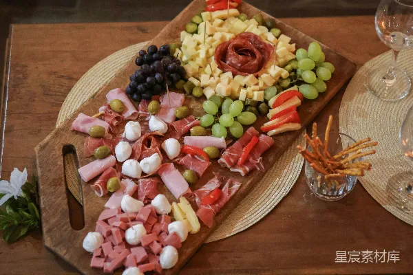高清摄影 各式奶酪、腌制肉类和新鲜葡萄的开胃菜板。