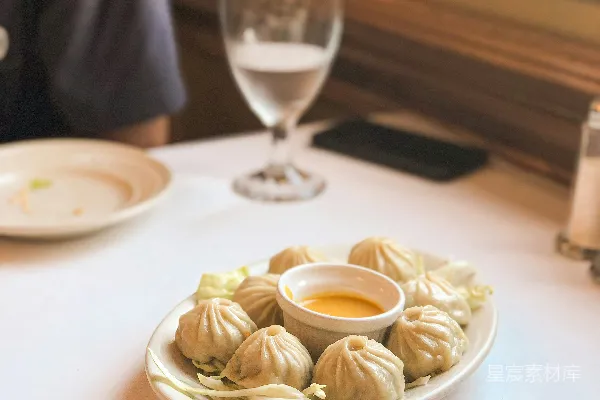 高清摄影 一个坐在桌子旁的人，旁边放着一盘食物。