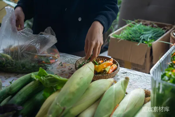 高清摄影 市场里手挑选彩色蔬菜和玉米。
