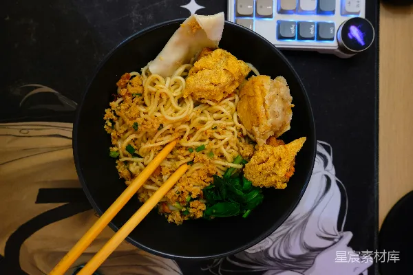 高清摄影 一碗配有饺子和绿叶蔬菜的面条