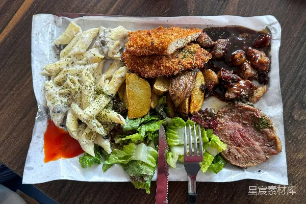 高清摄影 桌子上摆放着一盘食物，旁边有一把叉子和一把刀。