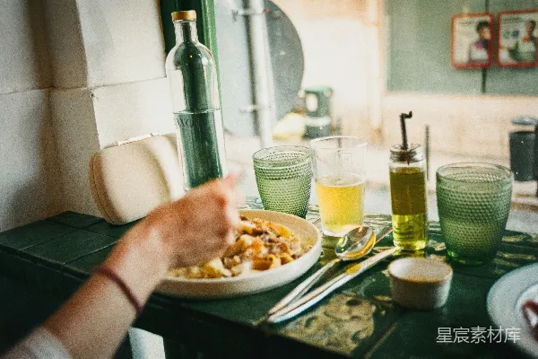高清摄影 手指向绿色桌面上的意面和饮料。