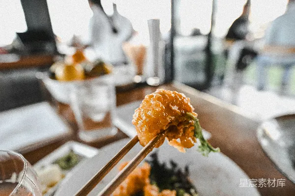 高清摄影 筷子夹着食物放在一个白色的盘子上。