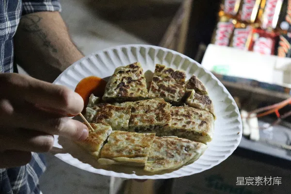 高清摄影 一个拿着纸盘的人，盘子里有食物。