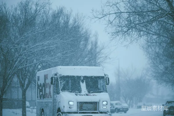 一辆白色卡车在覆雪的街道上行驶。