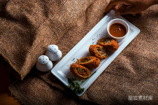 高清摄影 一个白色的盘子上摆放着食物，旁边是一杯酱料
