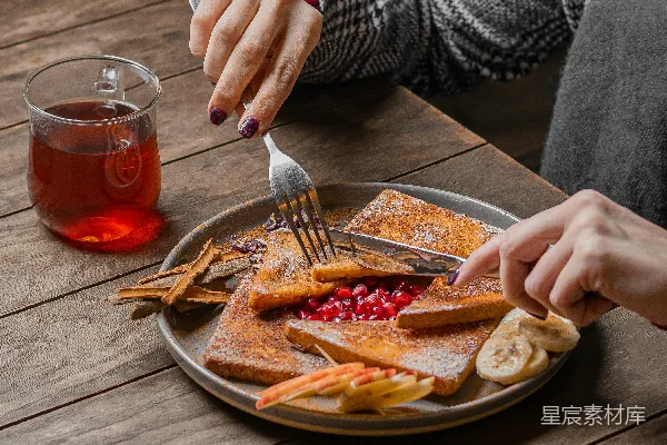 高清摄影 一位女性正在吃一盘 Pancakes 配有水果。
