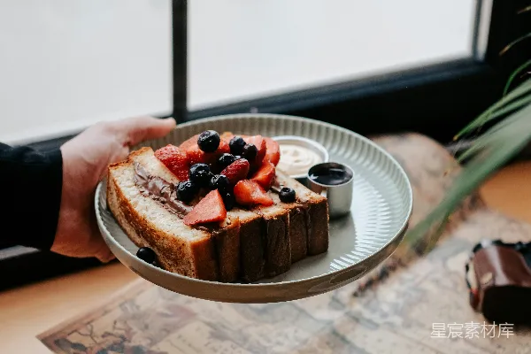 高清摄影 桌子上一个人拿着一盘食物。