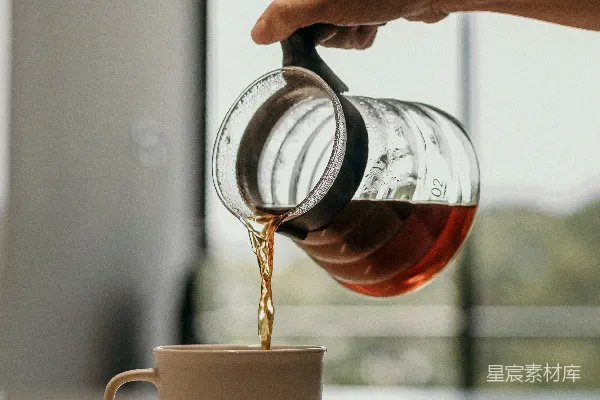 高清摄影 一个人在倒茶到白色的陶瓷杯里。
