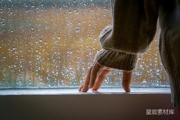 站在雨中的窗台上的人