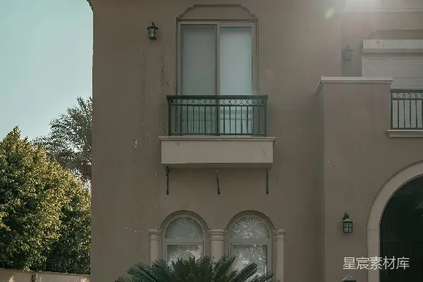 高清摄影 一座现代的米色房屋，旁边有一道黑色栅栏。