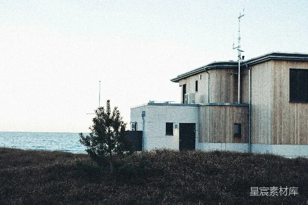 高清摄影 海边的现代房屋，周围是干草。
