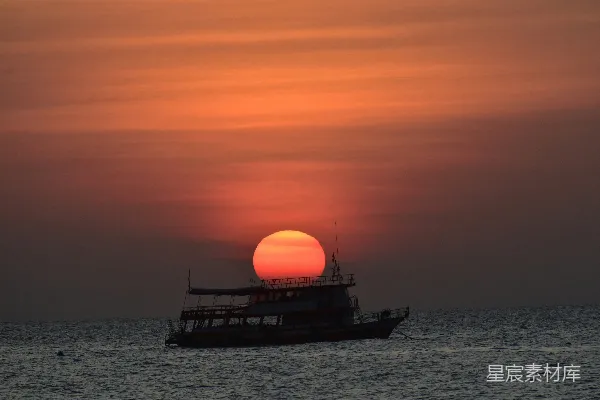 夕阳下的小船勾勒出海洋的轮廓。