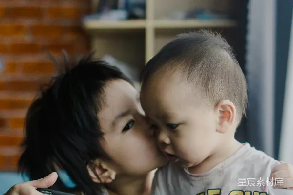 一个女人亲吻一个小孩子的脸颊