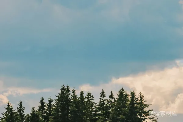 高清摄影 在多云的天空下，一座温暖的灰色小屋坐落在山坡上。