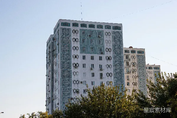 高清摄影 一座高大的白色建筑坐落在郁郁葱葱的绿色公园旁边。