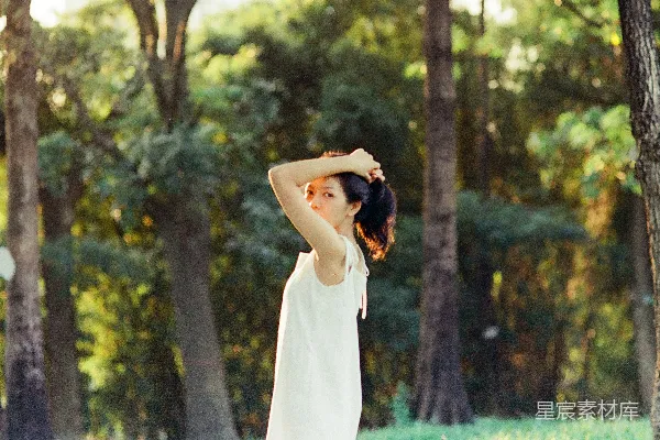 一位白裙女子站在森林中